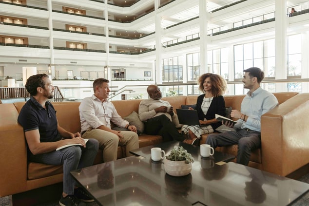 Five people meeting in lobby on sofa 
