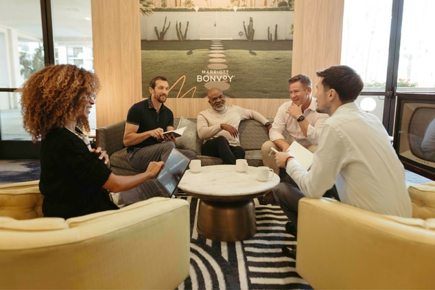 Five people meeting around a coffee table on a sof
