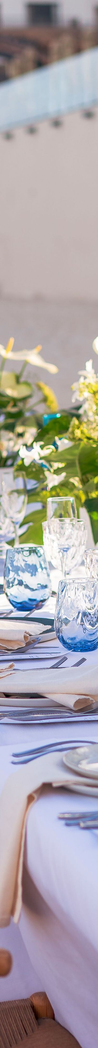 Una larga mesa de restaurante al aire libre elegantemente dispuesta.