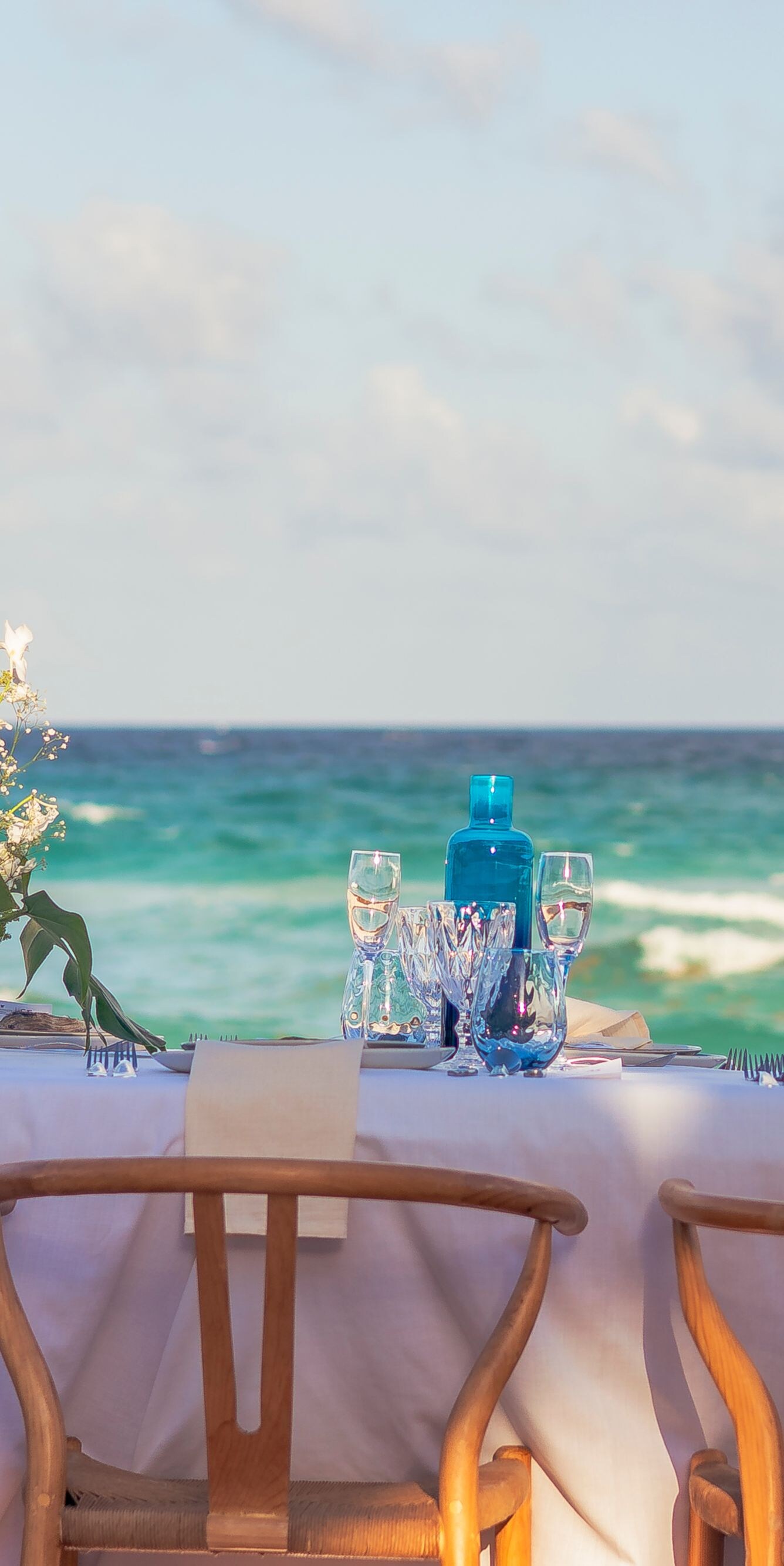 Una larga mesa de restaurante decorada con mantel blanco