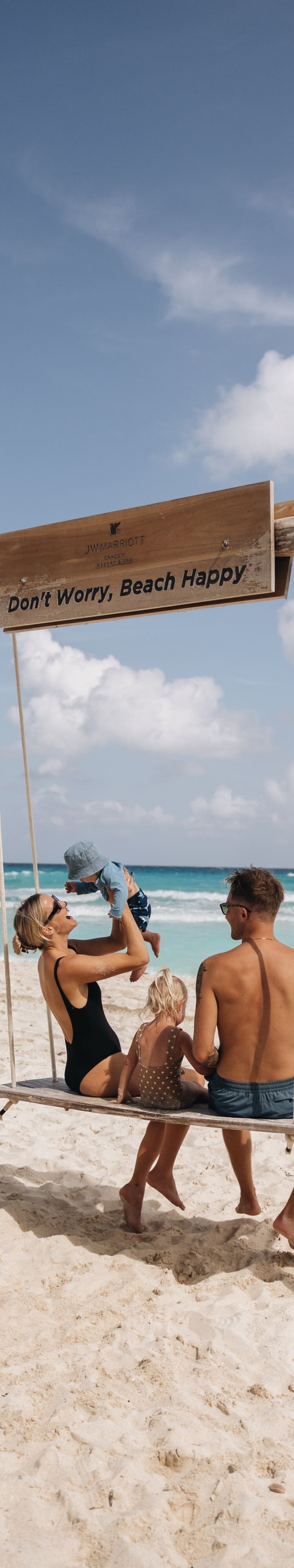 Guests enjoying a beach swing by the ocean