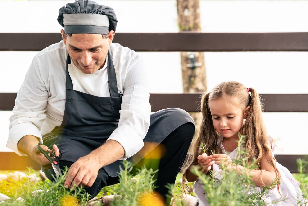 Chef in a garden with a child. 