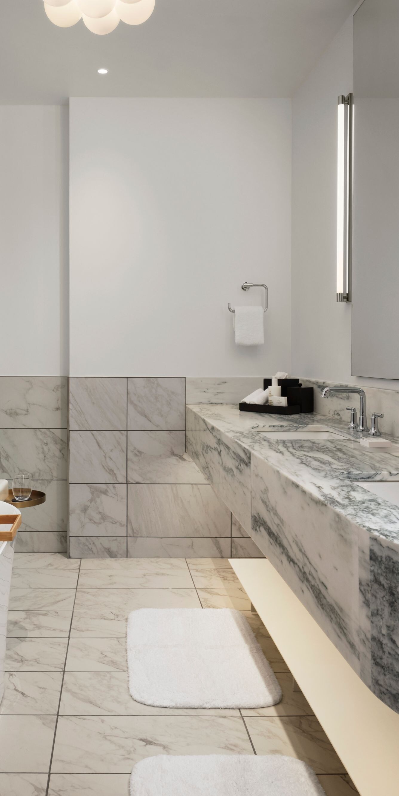 Bathroom with marble surfaces and tub