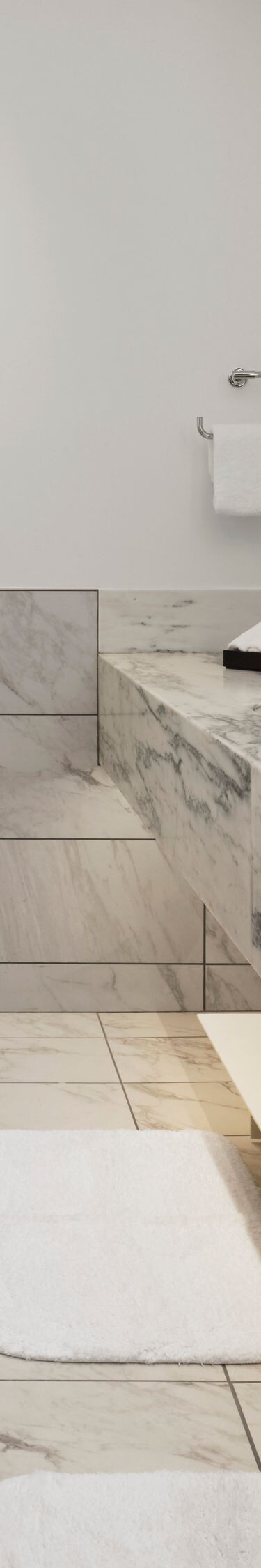 Bathroom with marble surfaces and tub