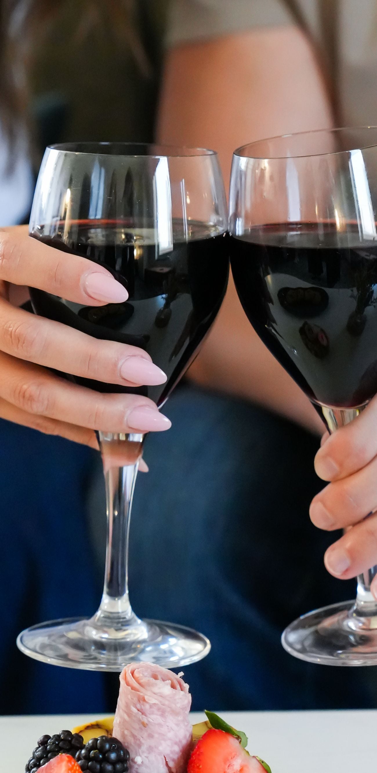 man and woman cheers wine glasses