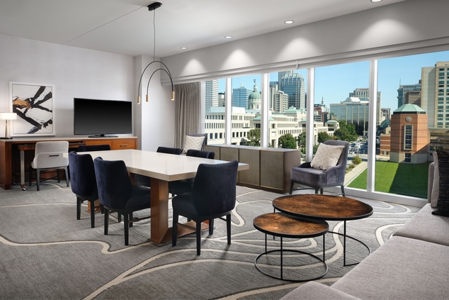 Suite with dining table and chairs with city view