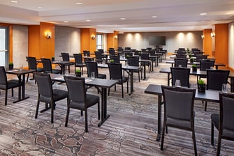 Indoor event room setup with classroom tables.