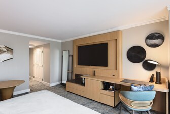 Ansicht des Zimmers mit großem Fernseher, Spiegel und Schreibtisch