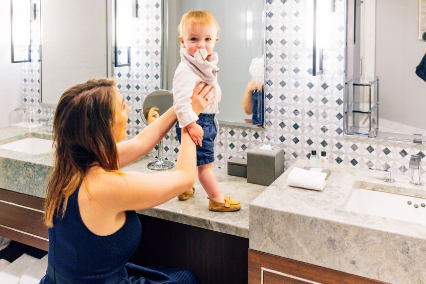 Woman and child at bathroom vanity.