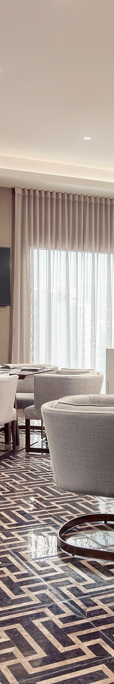 Lounge del hotel con mesas de restaurante y zona de asientos