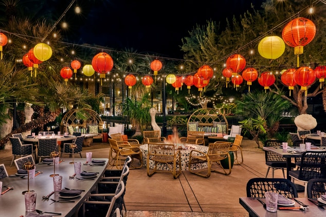 Patio tables with string lights and lanterns above