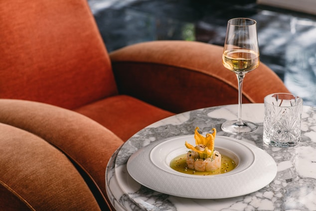 A comfortable chair and a signature dish with wine