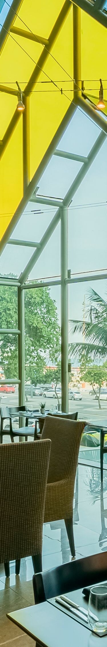 Vue du restaurant, grande fenêtre, chaises, tables.