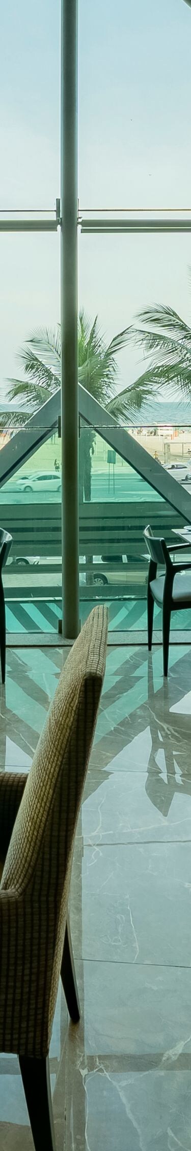 Vue du restaurant, grande fenêtre, chaises, tables.