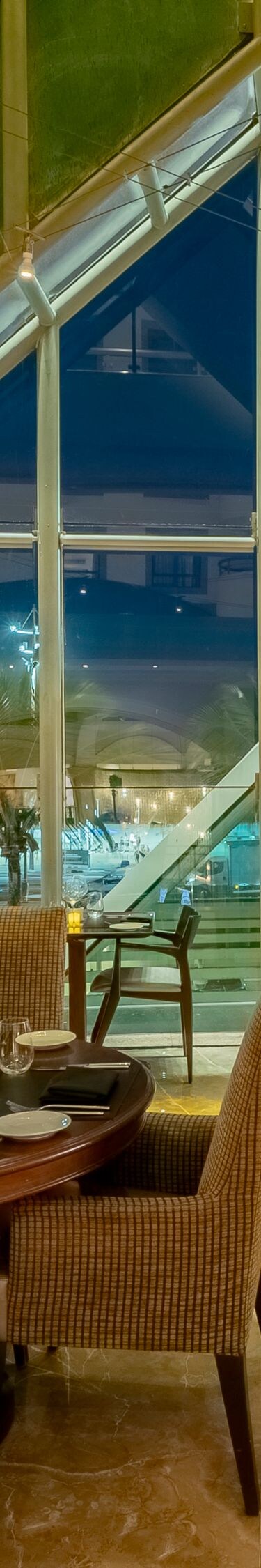 Vue du restaurant, grande fenêtre, chaises, tables.