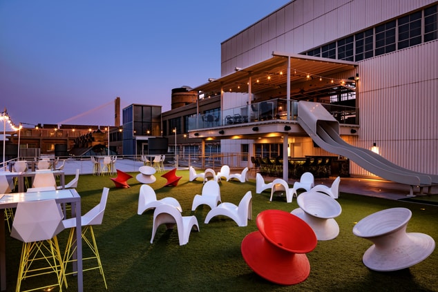 rooftop bar with a slide, chairs and view
