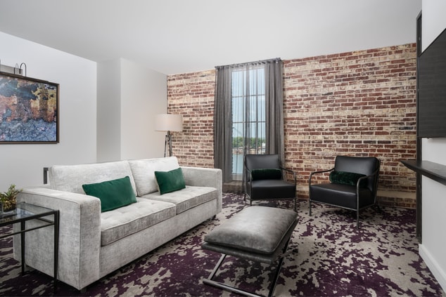 couch with brick wall and additional chairs