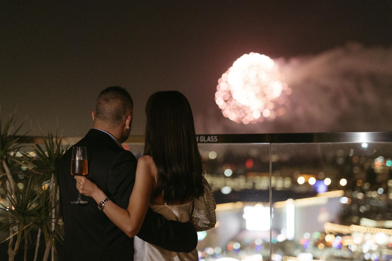 A man and woman watching fireworks at night
