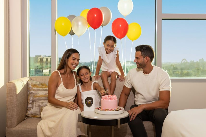 Familia celebrando junto con pastel y globos