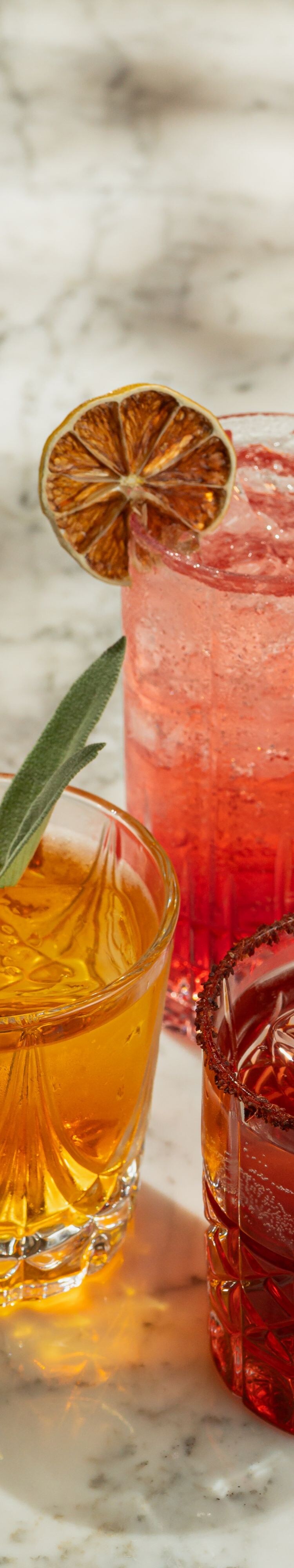 Three signature cocktails on a bar counter