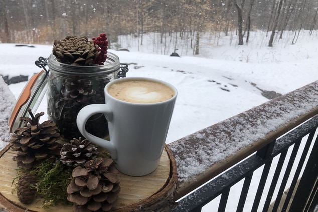 Warm Chai Latte sitting on porch ledge with a snow