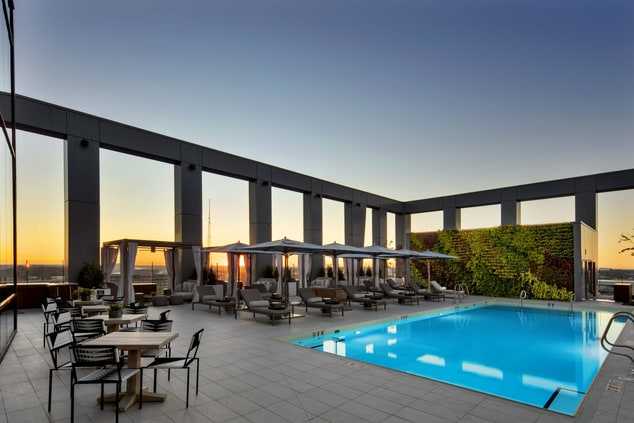Expansive rooftop pool with tables, private cabana