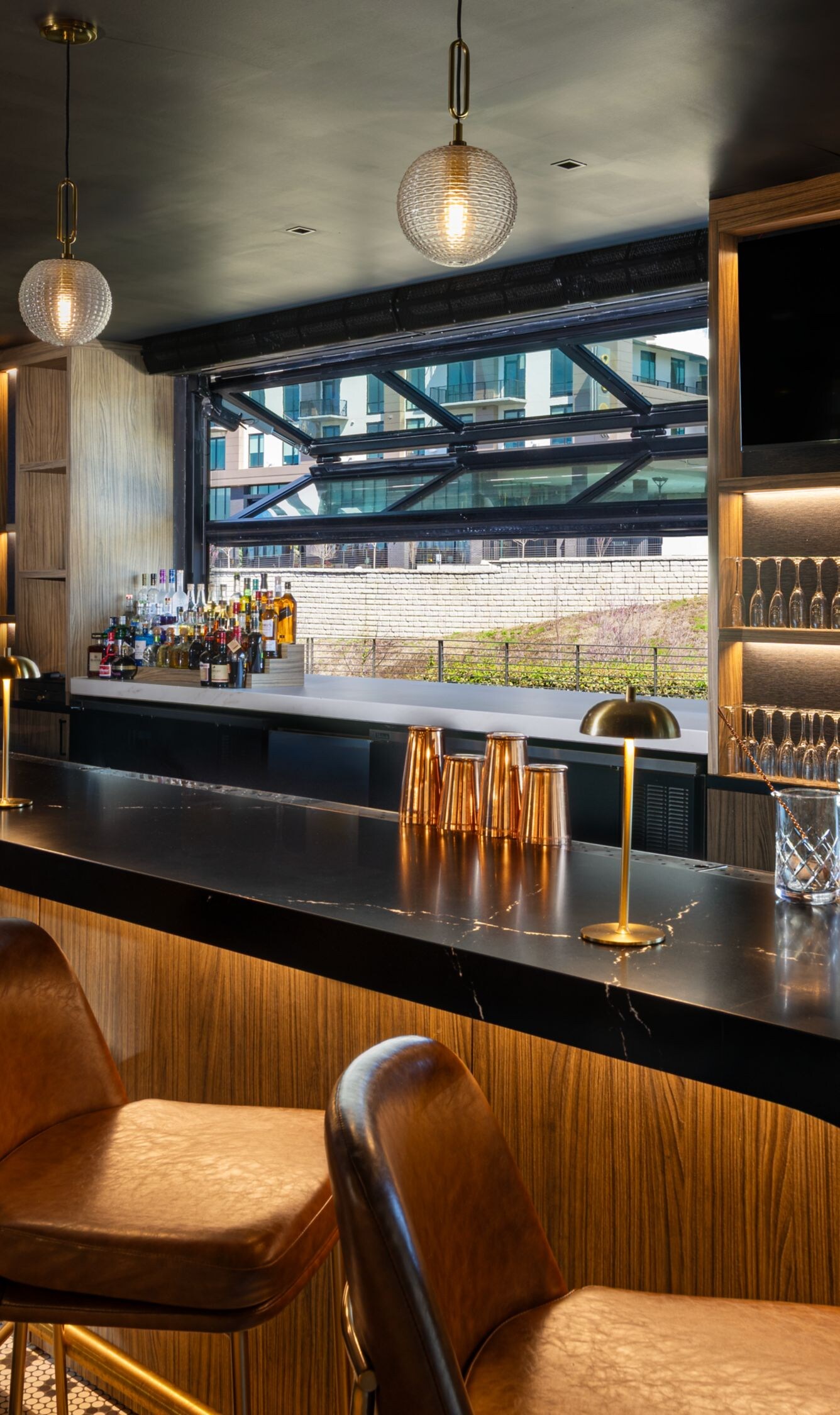 Modern bar with stools and backlit liquor shelves