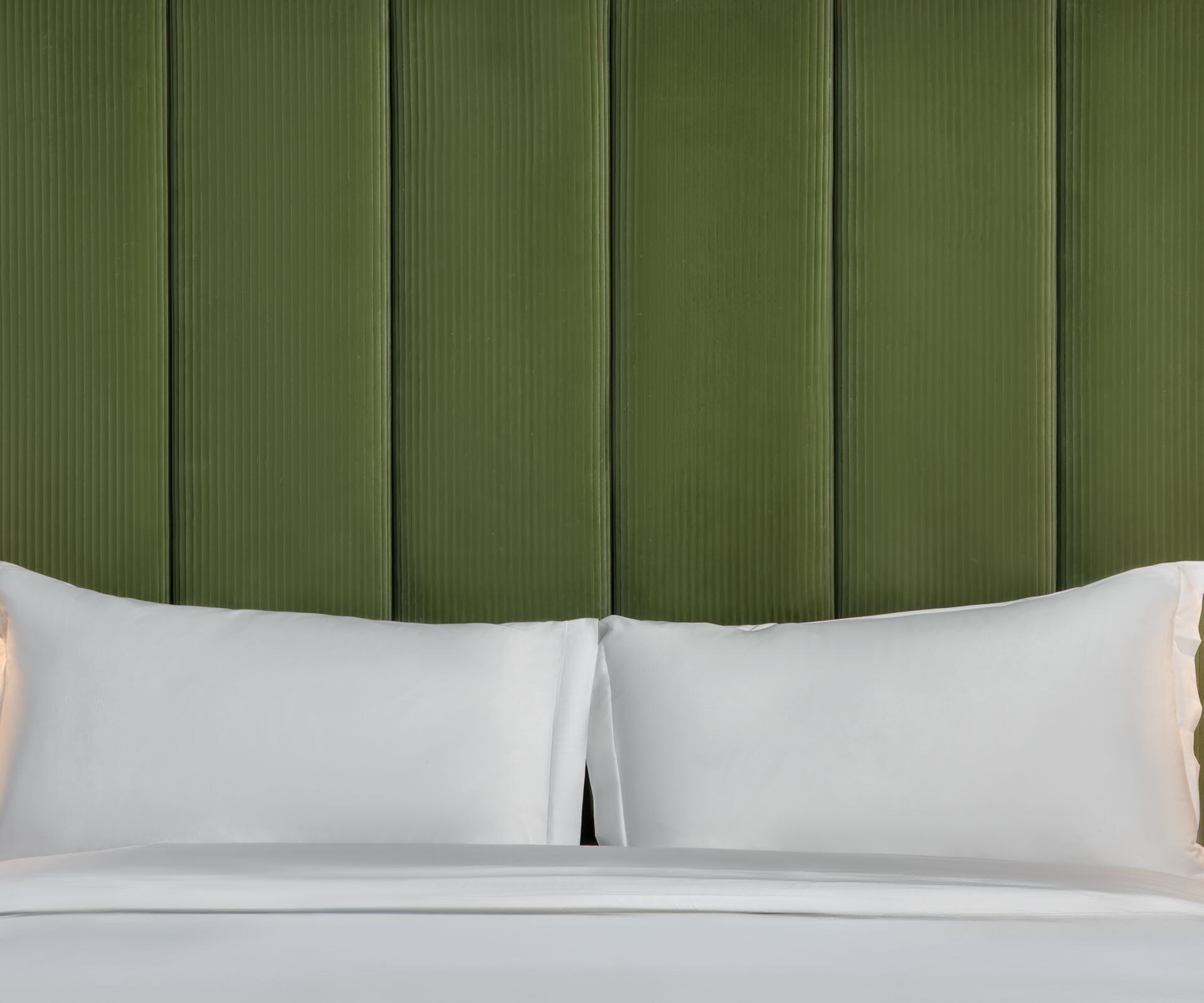bed with green headboard and lamps