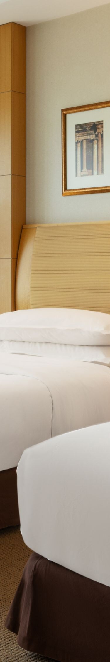 Twin beds beside floor-to-ceiling windows