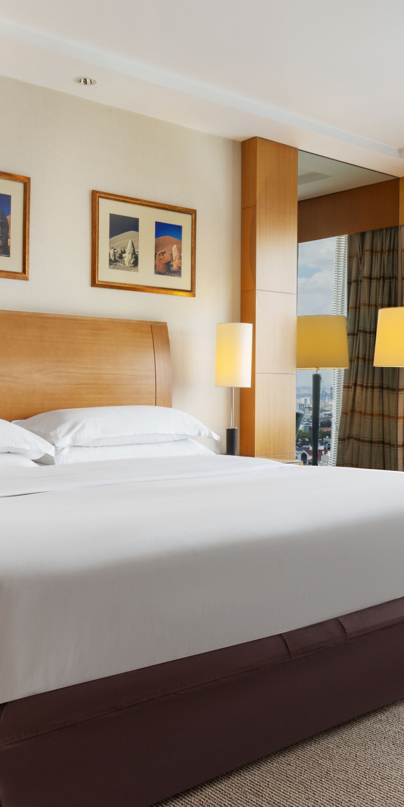 King bed beside floor-to-ceiling windows