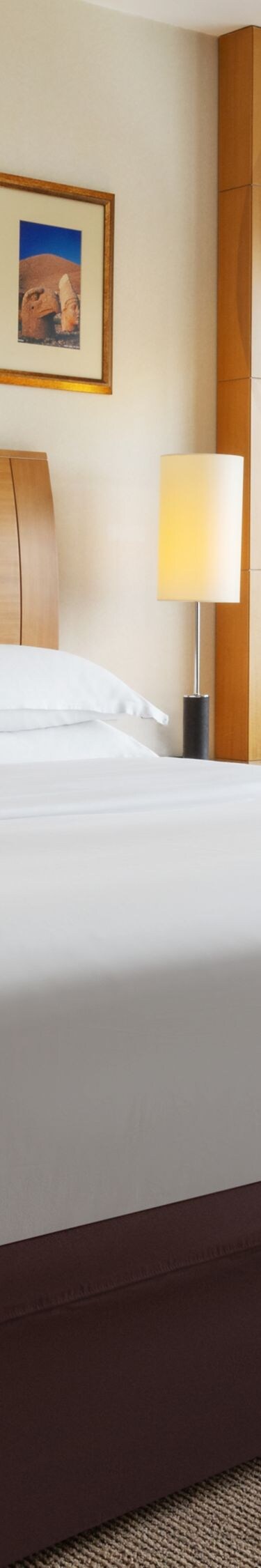 King bed beside floor-to-ceiling windows