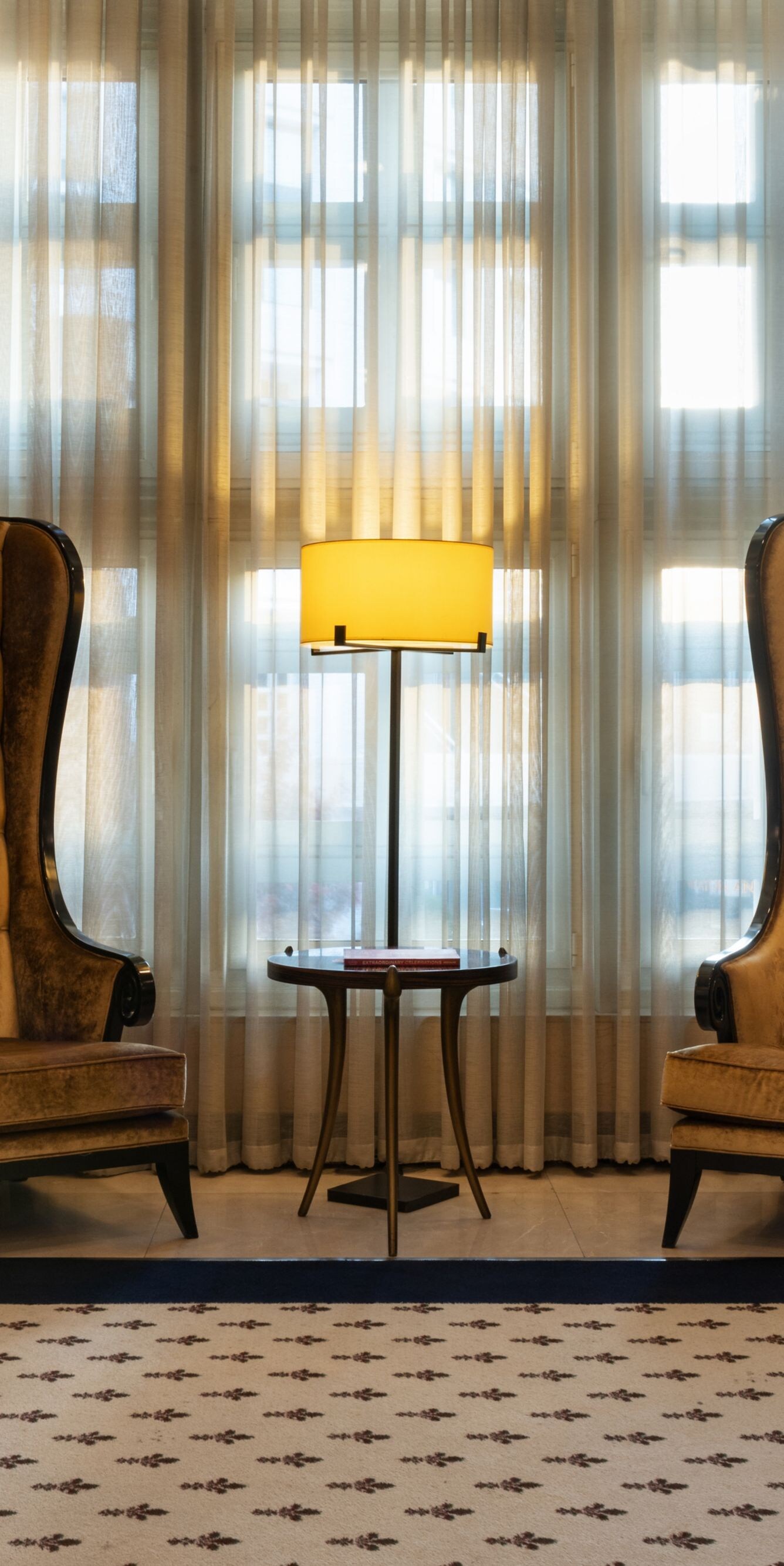 Two high-back chairs beside lobby windows