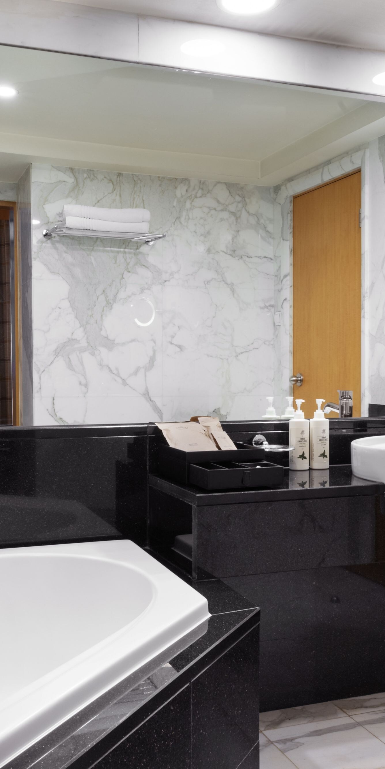 Marble bathroom with bathtub and large mirror