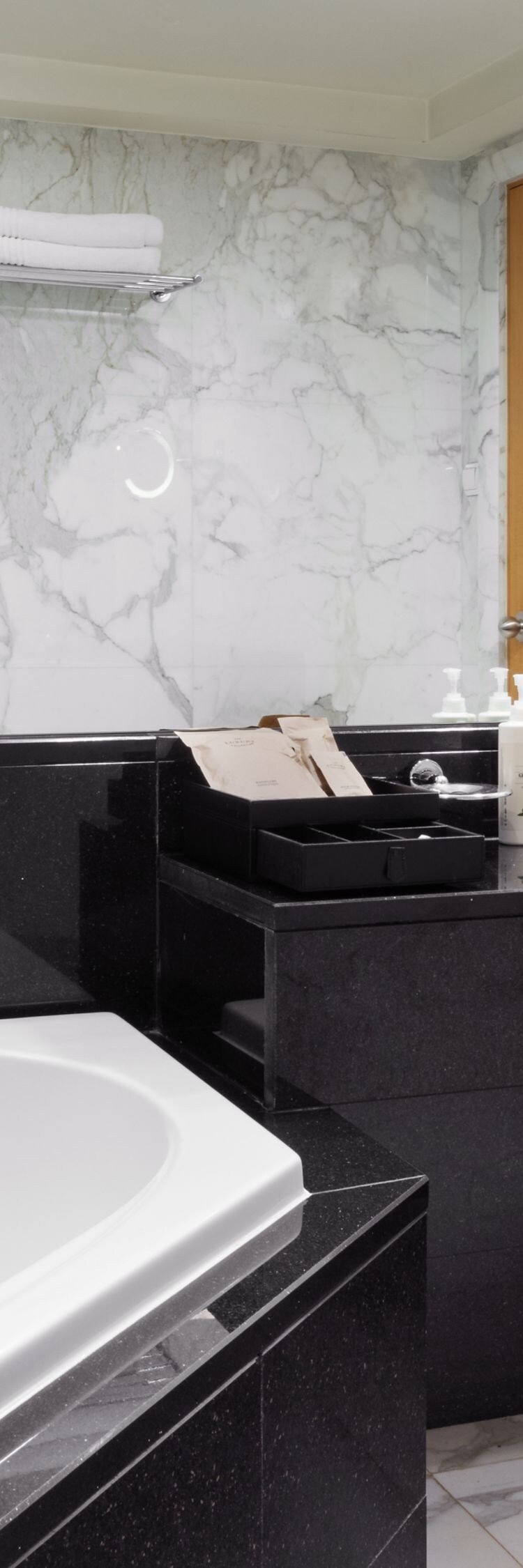 Marble bathroom with bathtub and large mirror