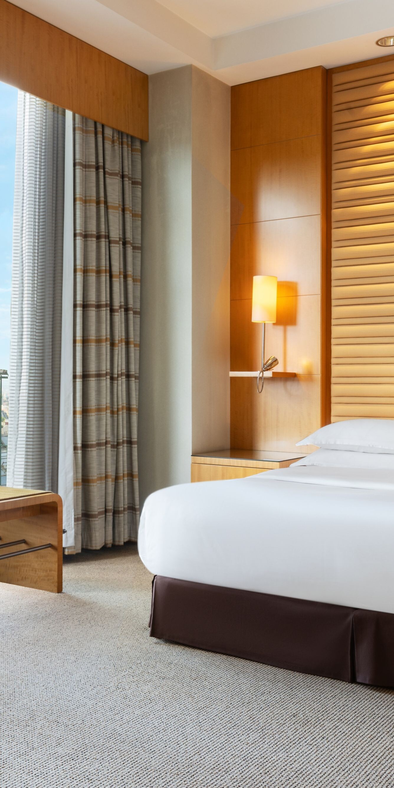 King bedroom with large windows and city view