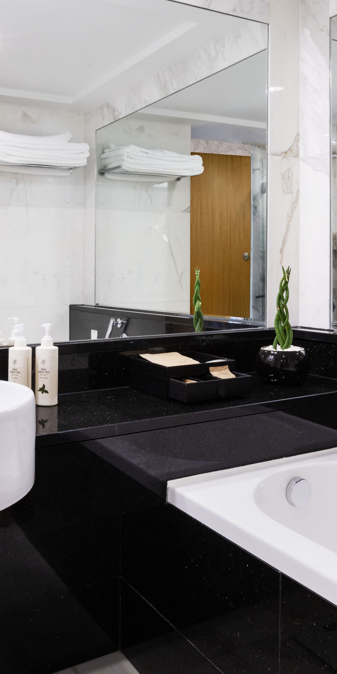 Marble bathroom with bathtub and large mirrors