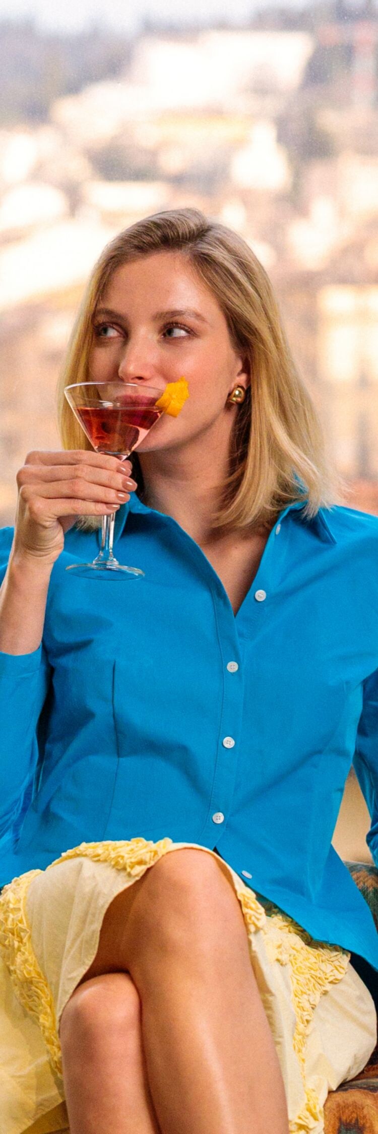 Une femme boit un apéritif avec vue sur la ligne d'horizon de Florence.