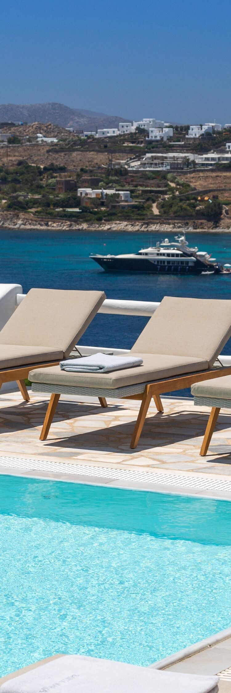 Piscina, sillas para tomar el sol, vista al mar