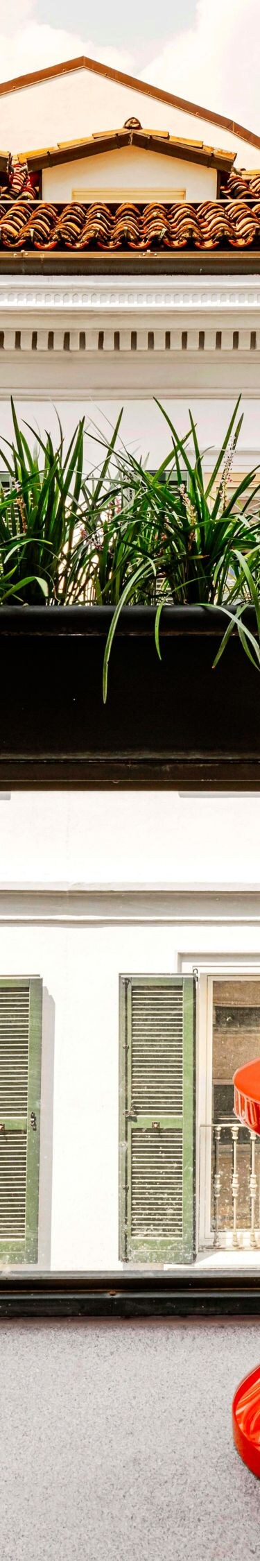 balcony with red table and plants