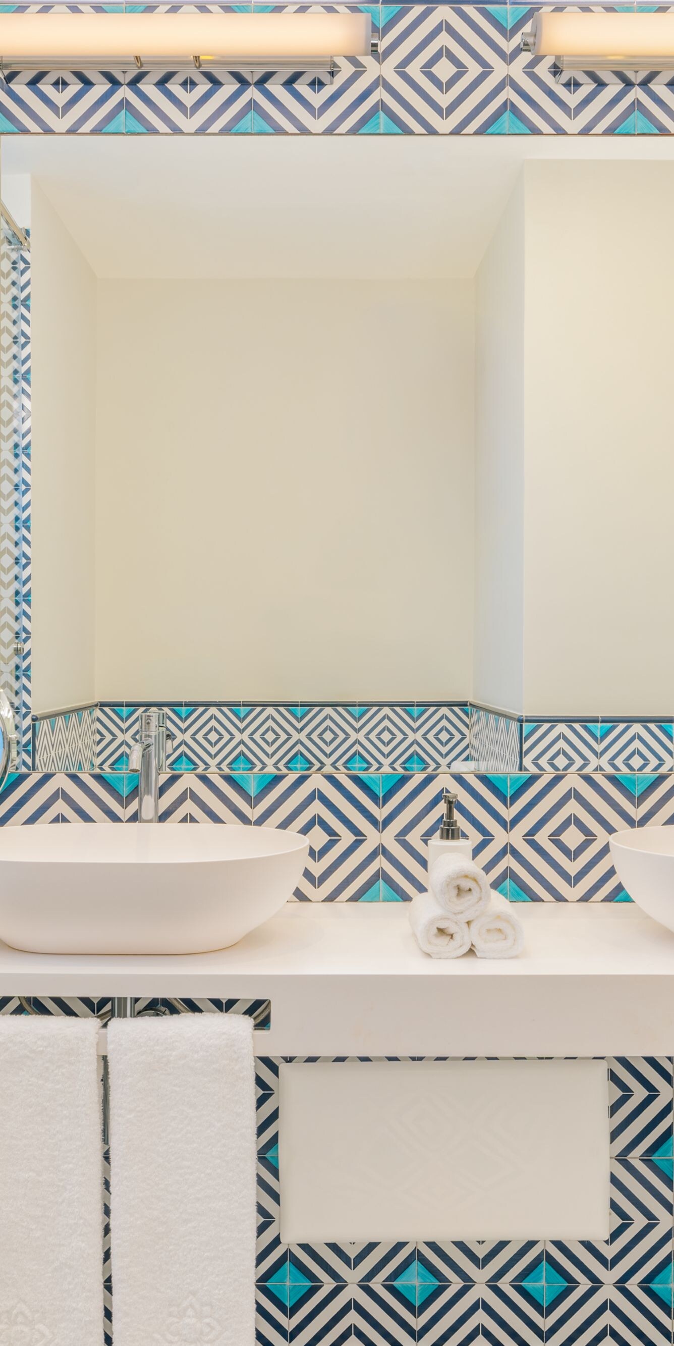 bathroom with dual sinks and patterned tiles