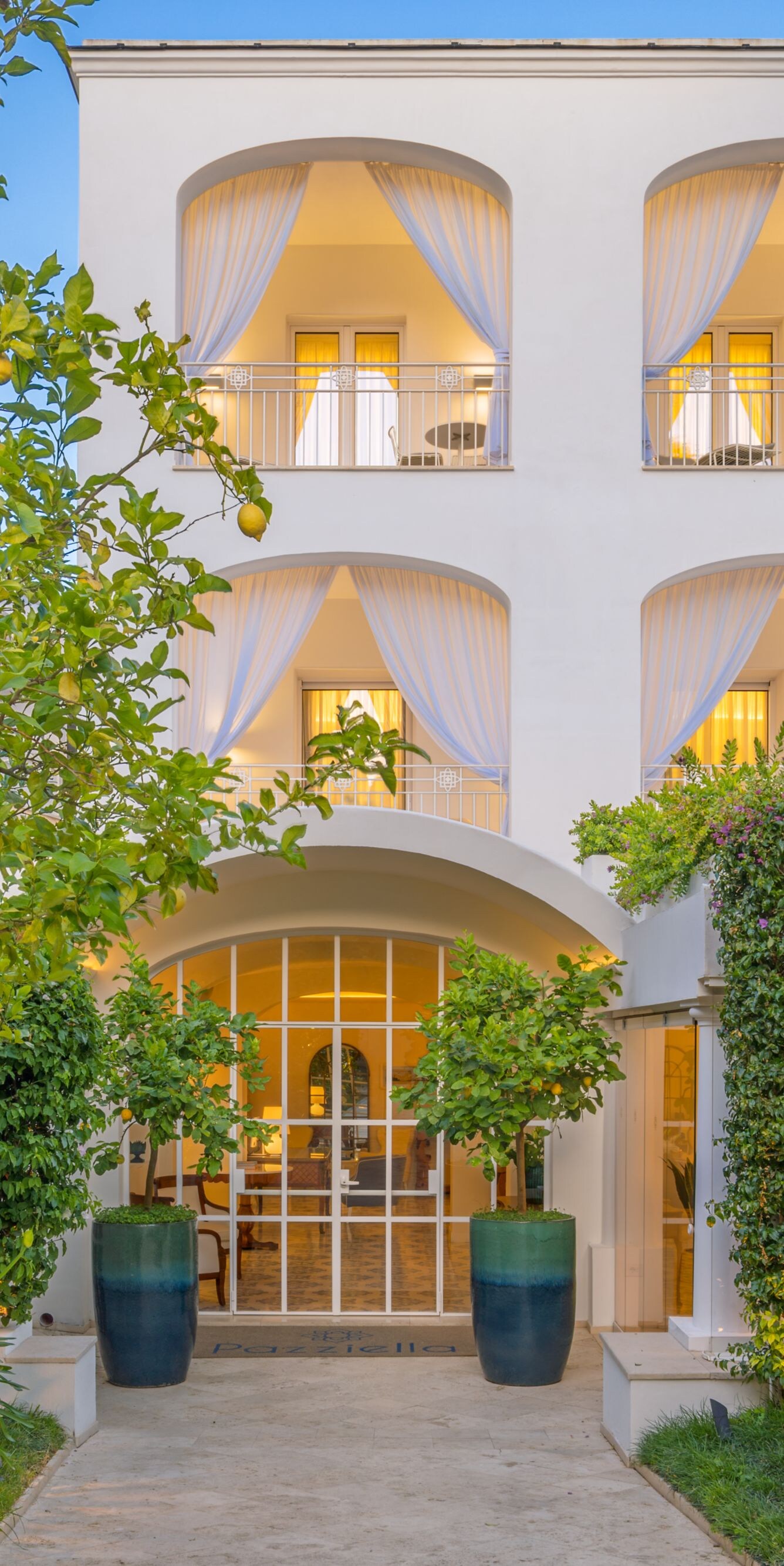 Exterior hotel entrance surrounded by lush gardens