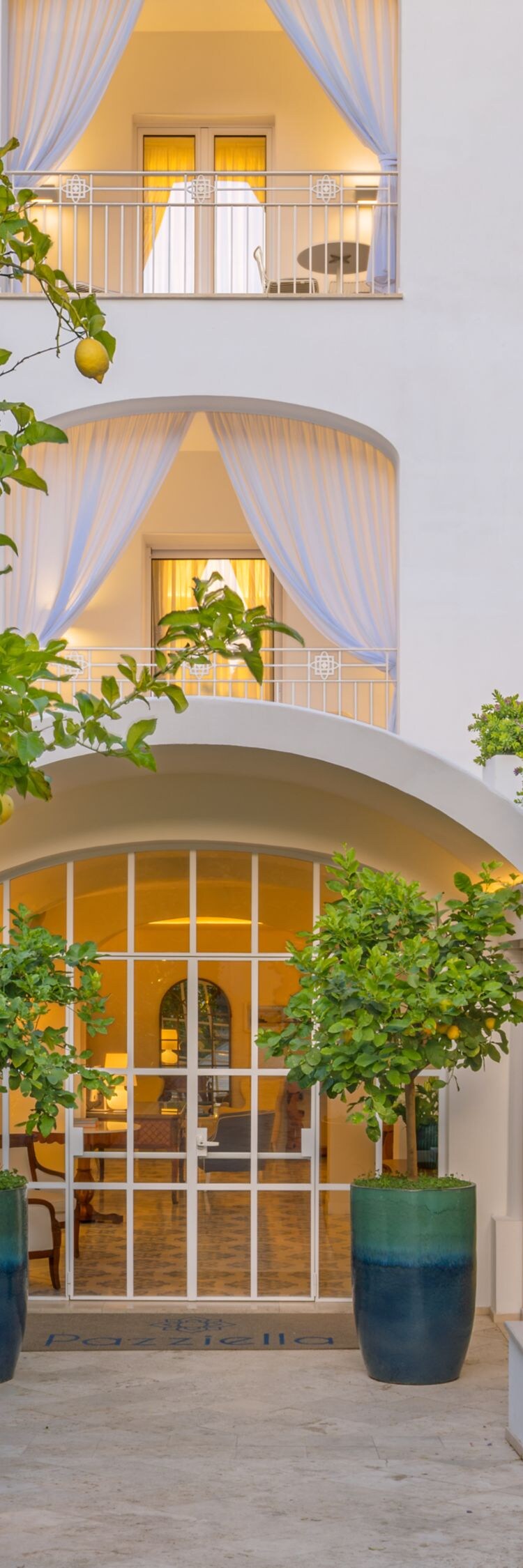 Exterior hotel entrance surrounded by lush gardens