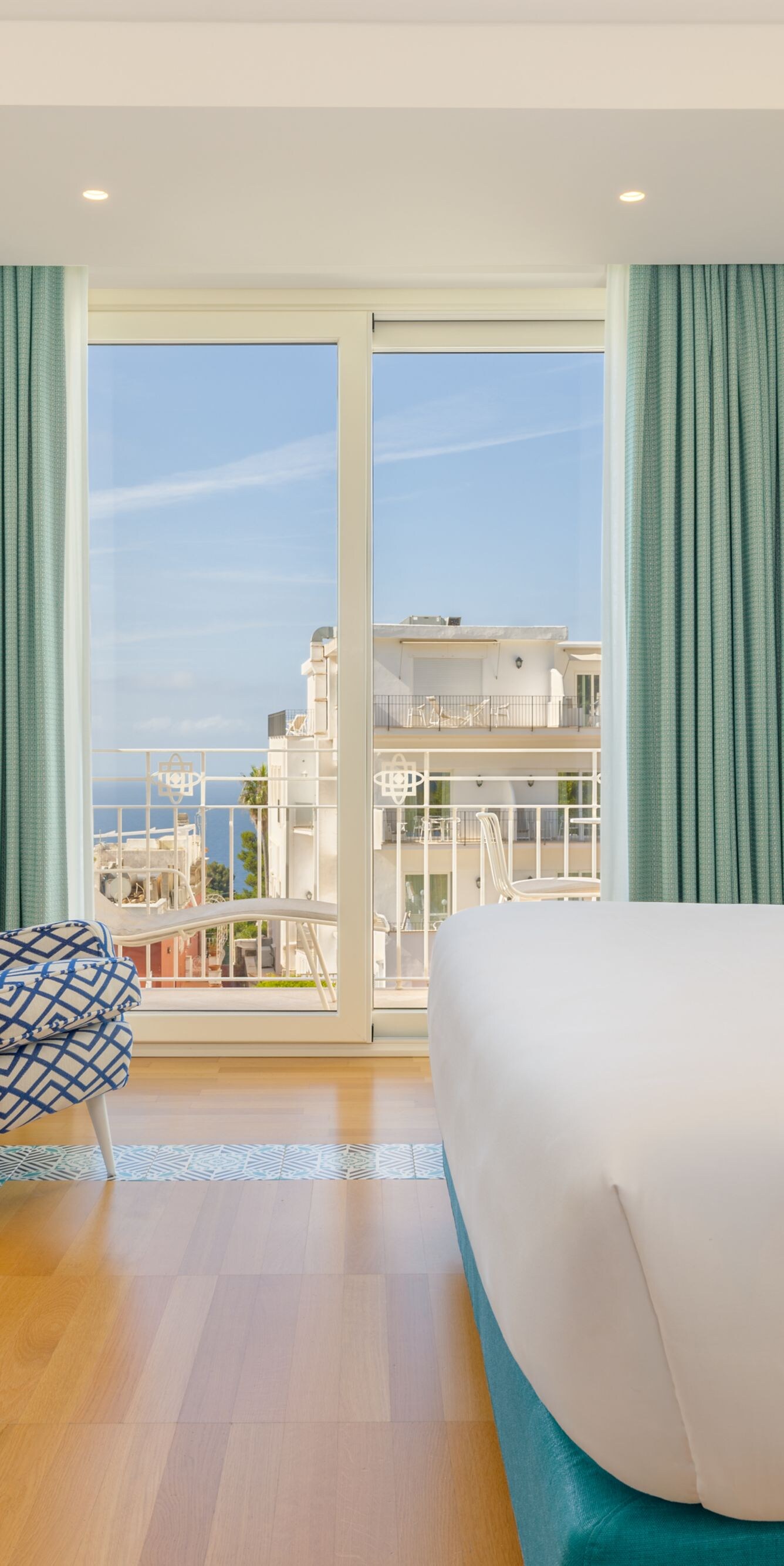 Guest room with desk, chair and balcony view