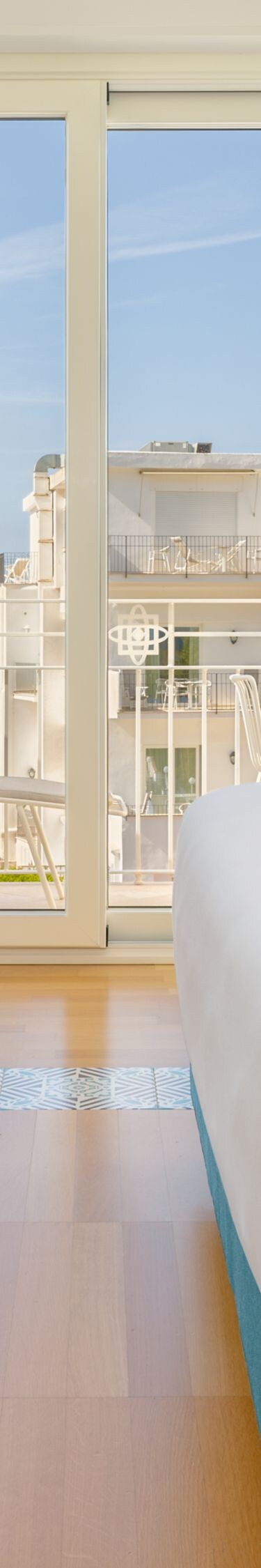 Guest room with desk, chair and balcony view
