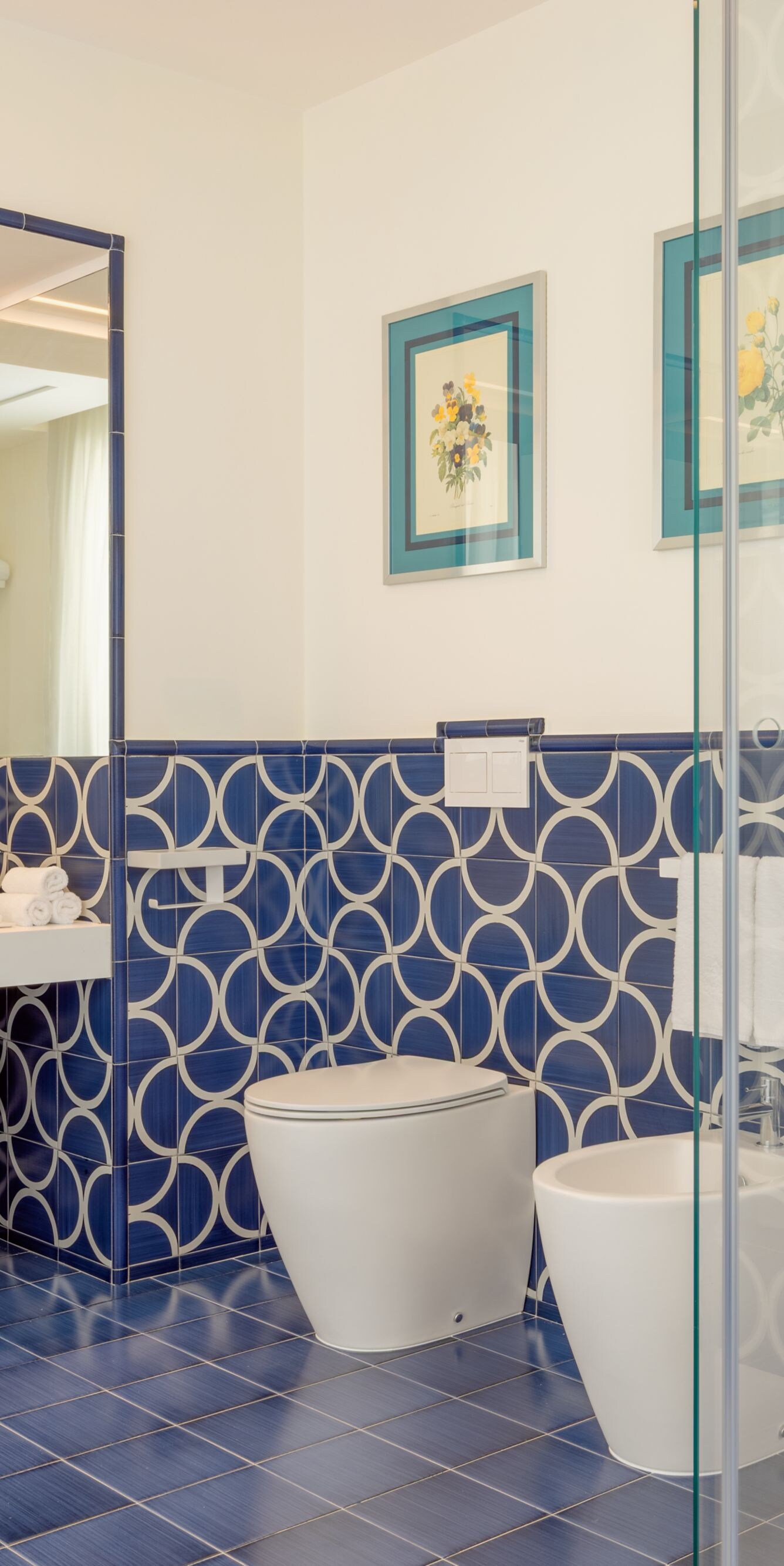 Blue tiled bathroom with walk-in glass shower