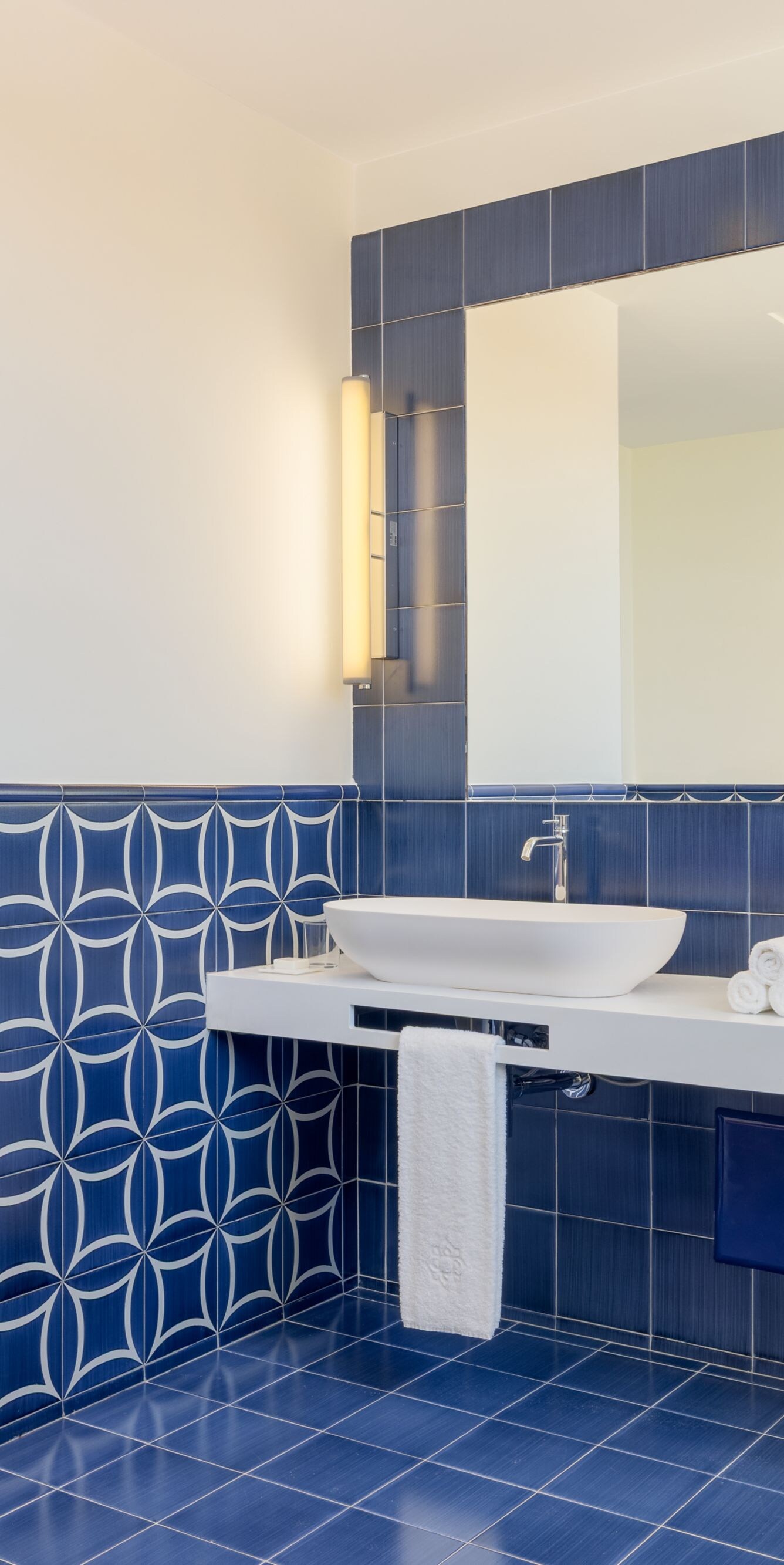 Blue tiled bathroom with double sinks and shower 