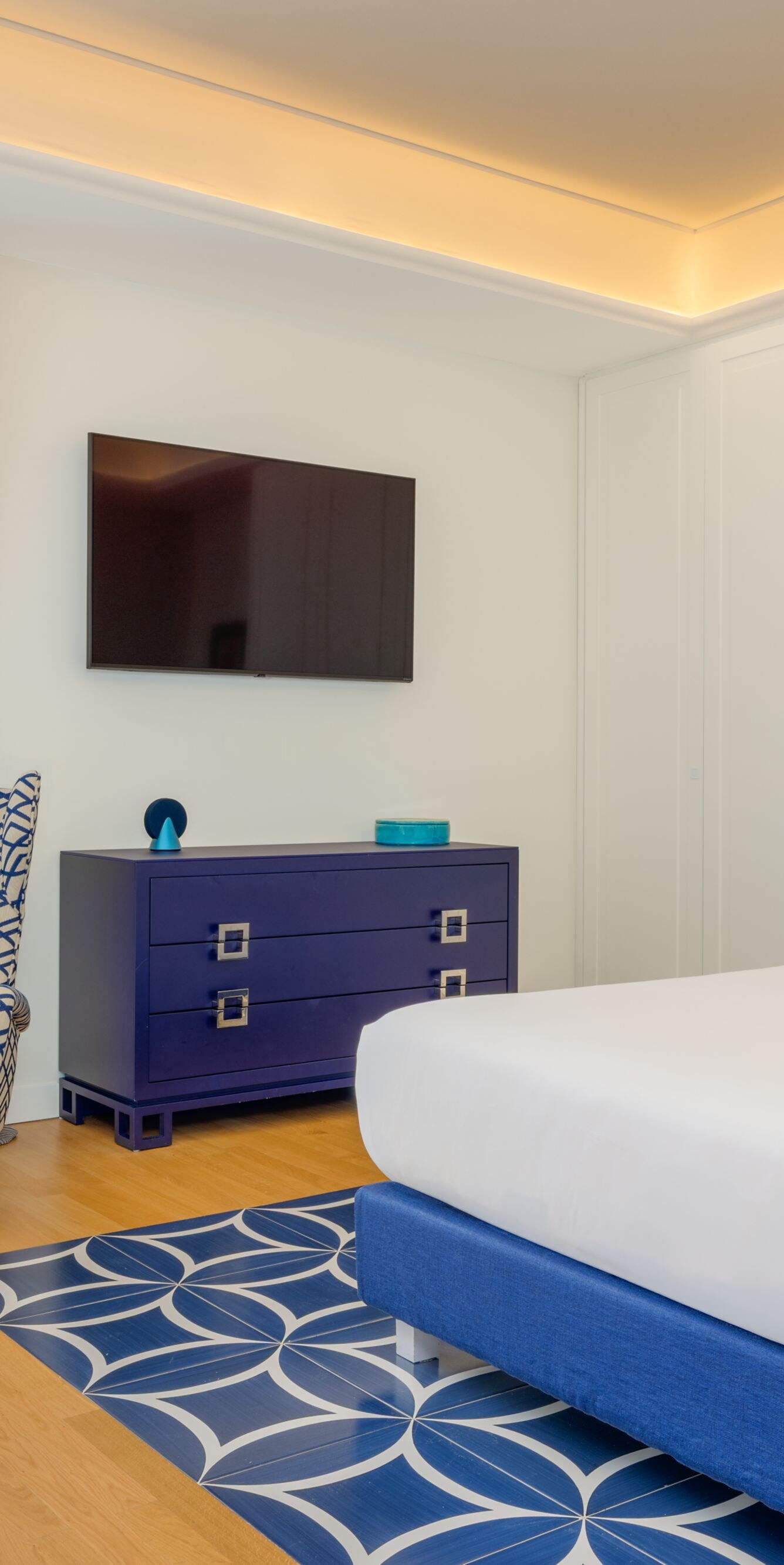 Spacious guest room with bed, chair and balcony 