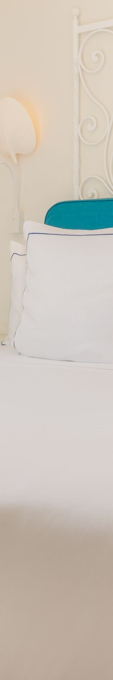 King bed with turquoise headboard and balcony door