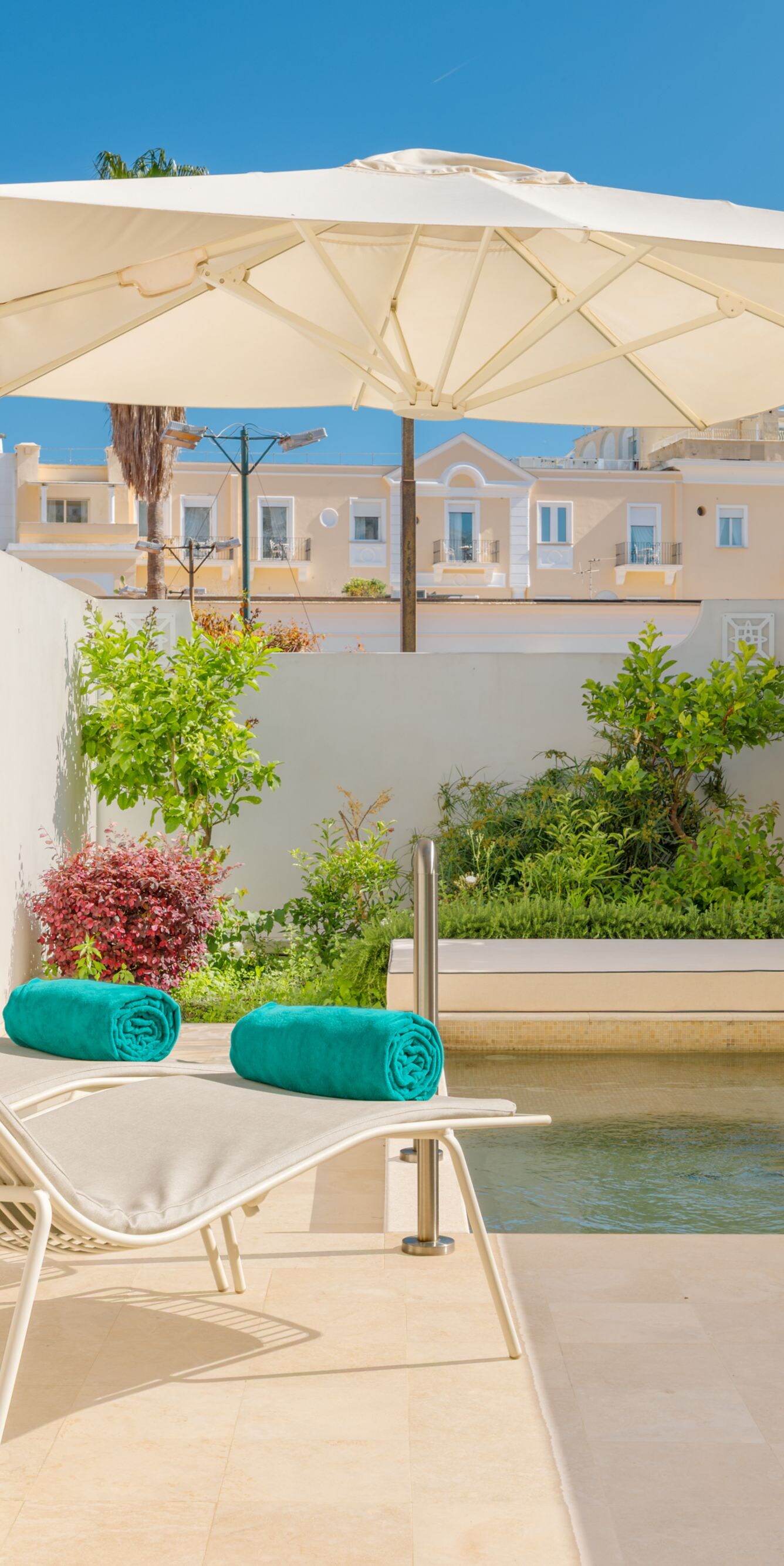 Private patio pool with lounge chairs and umbrella