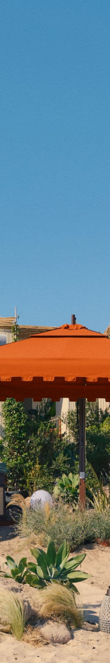 Beachfront cabanas with orange umbrellas and sandy
